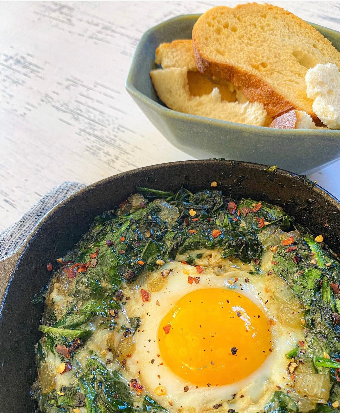 Spinach egg nest in a cast iron with crostini's. super easy to make and savory.
